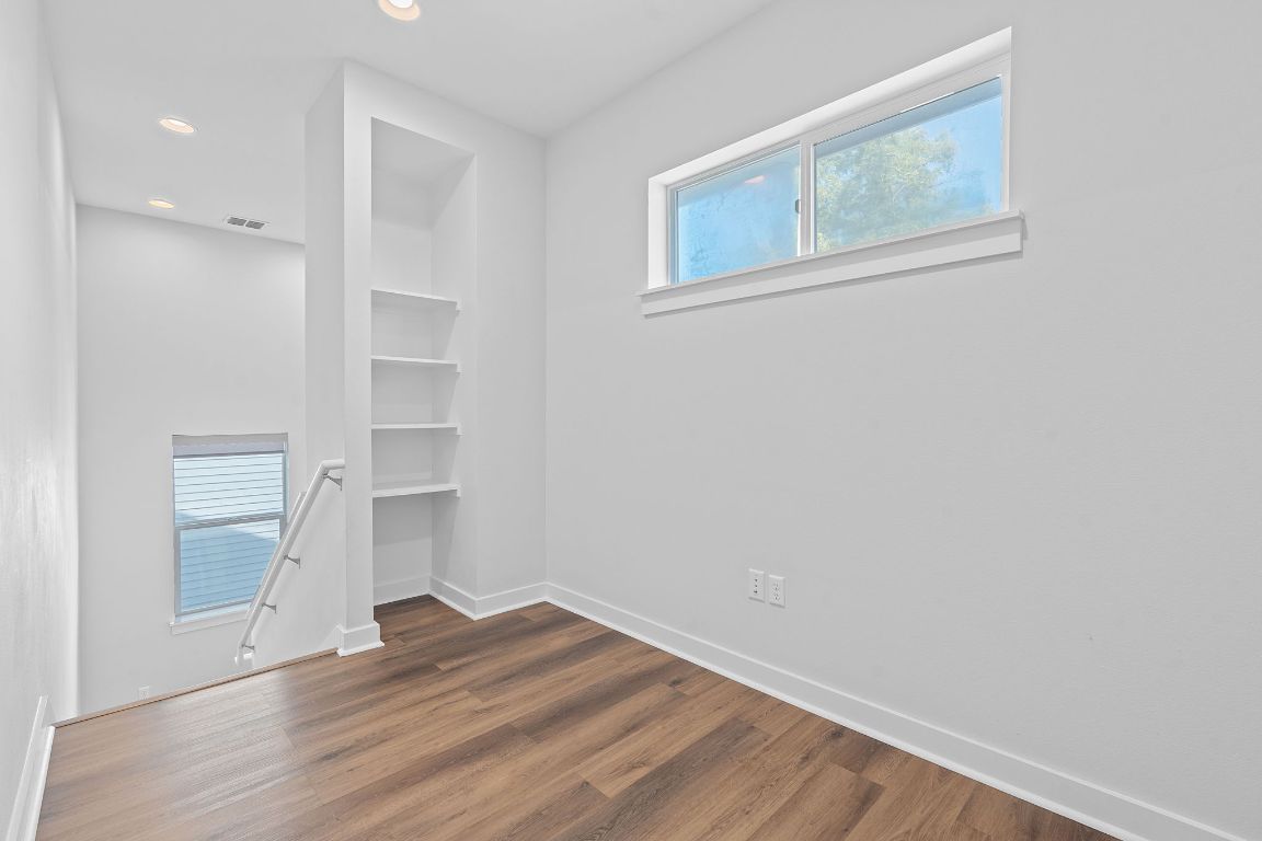 301 West Stassney Lane, Unit 7 Austin, TX 78745 - Photo 24 of 30 an empty room with wooden floor and windows