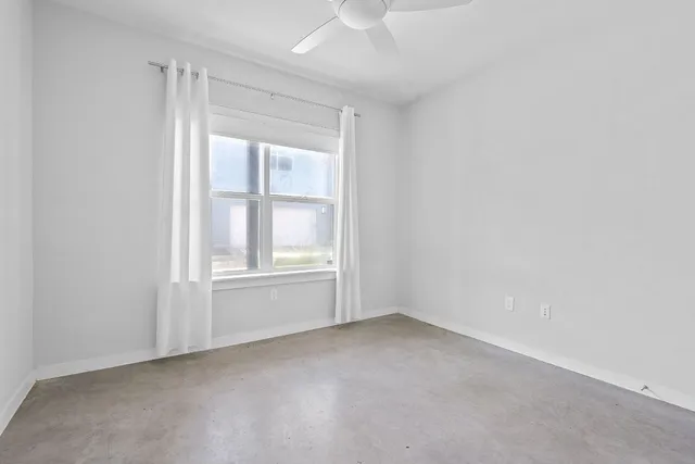 an empty room with windows and closet