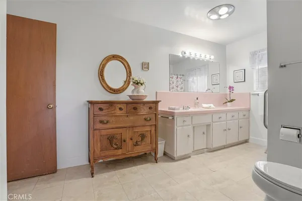 a bathroom with a granite countertop sink mirror vanity and toilet