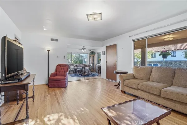 a living room with furniture a flat screen tv and a large window