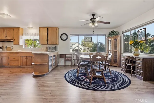 a living room with furniture a large window and dining table