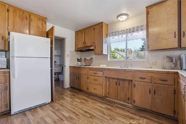 a kitchen with sink refrigerator and cabinets