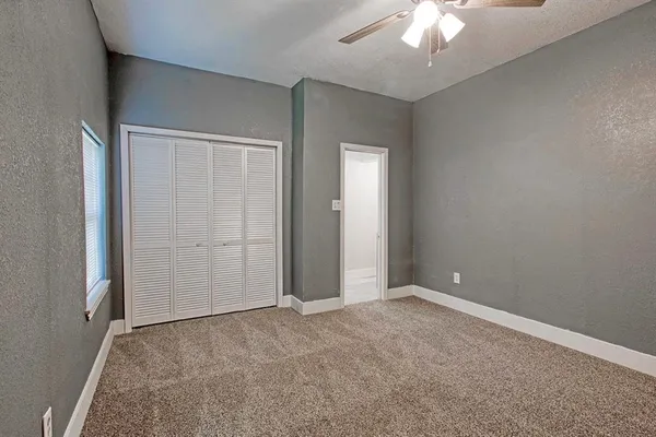 an empty room with a chandelier fan