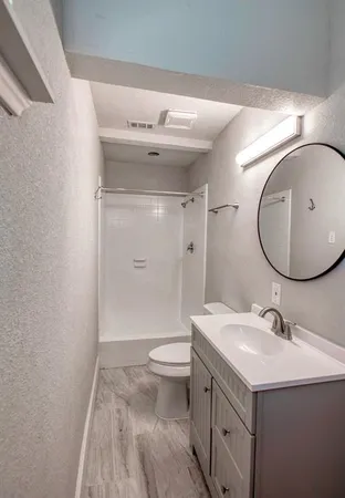 a bathroom with a sink toilet and shower