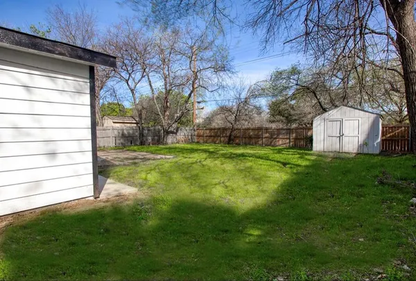 a view of a backyard with large trees