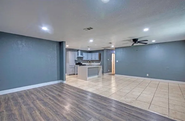 a view of kitchen with kitchen island microwave and wooden floor