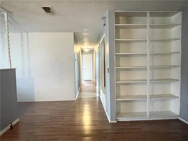 a view of a room with wooden floor and a window