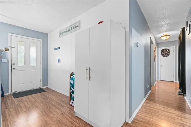 a view of a hallway with wooden floor and stairs