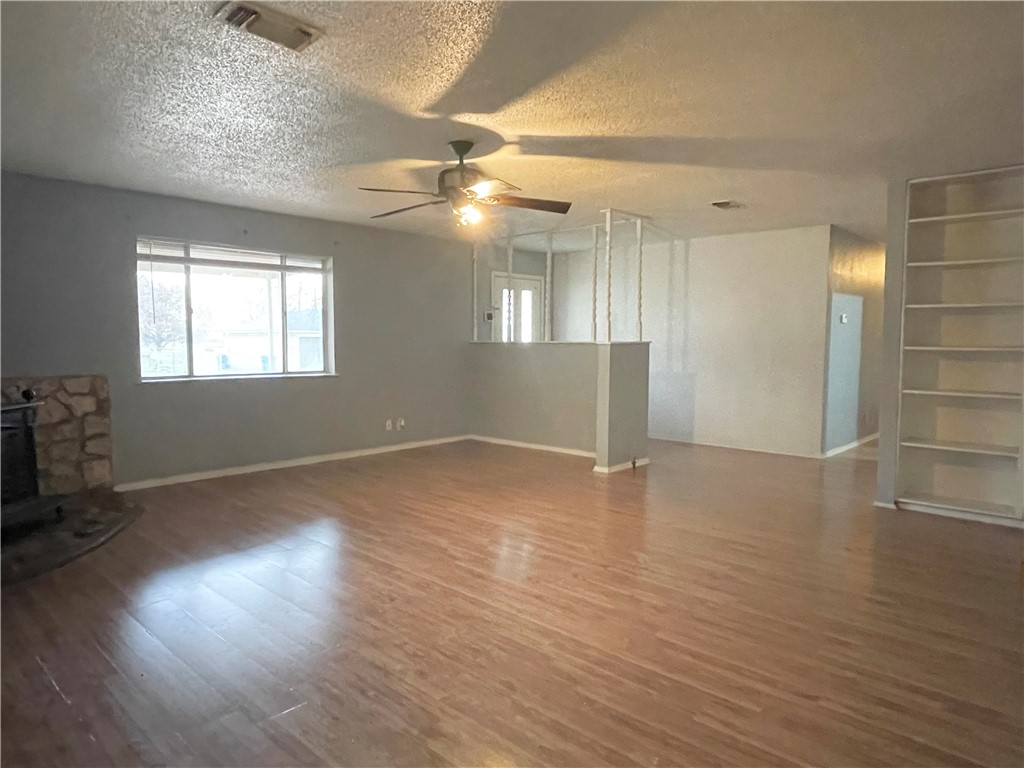 133 Wayman Drive Whitney, TX 76692 - Photo 9 of 38 an empty room with wooden floor and windows