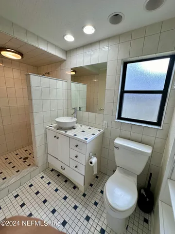 a bathroom with a sink toilet vanity and shower