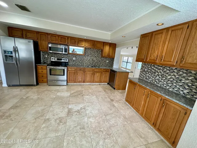 a kitchen with stainless steel appliances a refrigerator and wooden cabinets