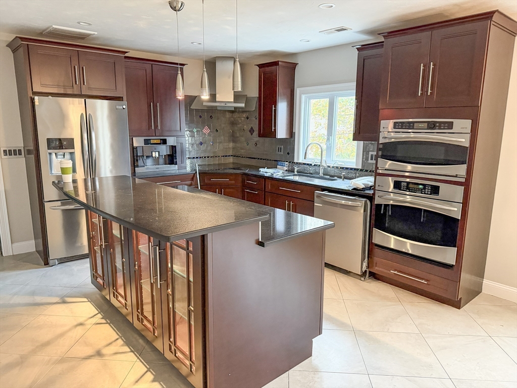 1132 West Boylston Street, Unit 2 Worcester, MA 01606 - Photo 1 of 42 a kitchen with stainless steel appliances granite countertop a stove a refrigerator and a sink with wooden cabinets