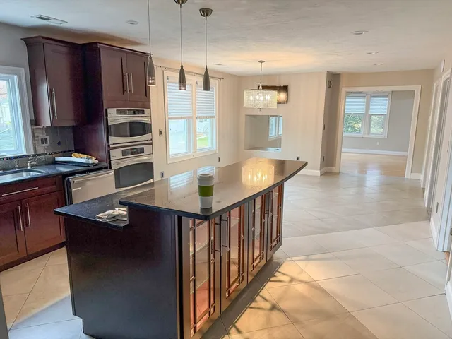 a kitchen with stainless steel appliances granite countertop a refrigerator a sink and wooden cabinets