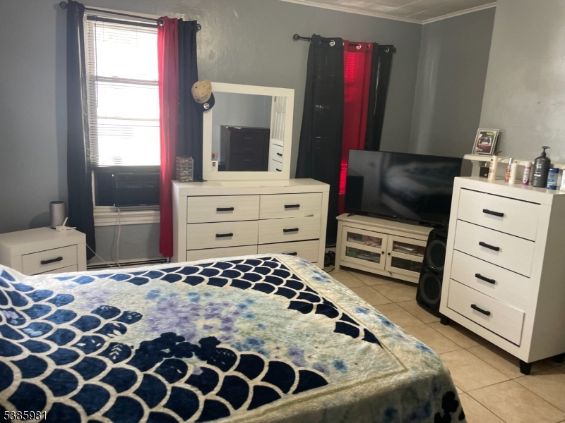 63 Front Street Paterson, NJ 07522 - Photo 2 of 17 a bedroom with a bed and wooden floor
