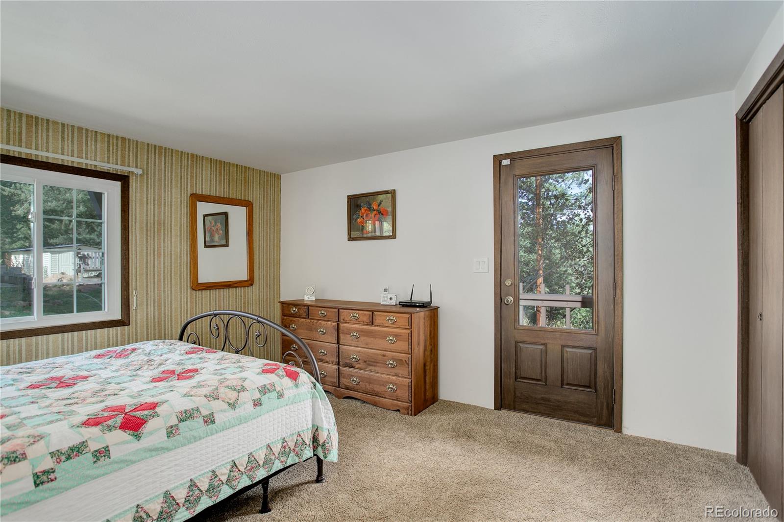 19285 Fox Den Way Morrison, CO 80465 - Photo 12 of 24 a bedroom with a bed dresser and window