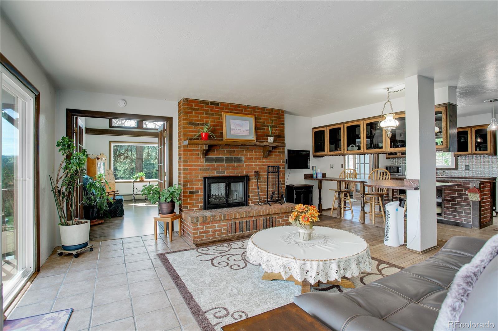 19285 Fox Den Way Morrison, CO 80465 - Photo 15 of 24 a living room with furniture a fireplace and a flat screen tv