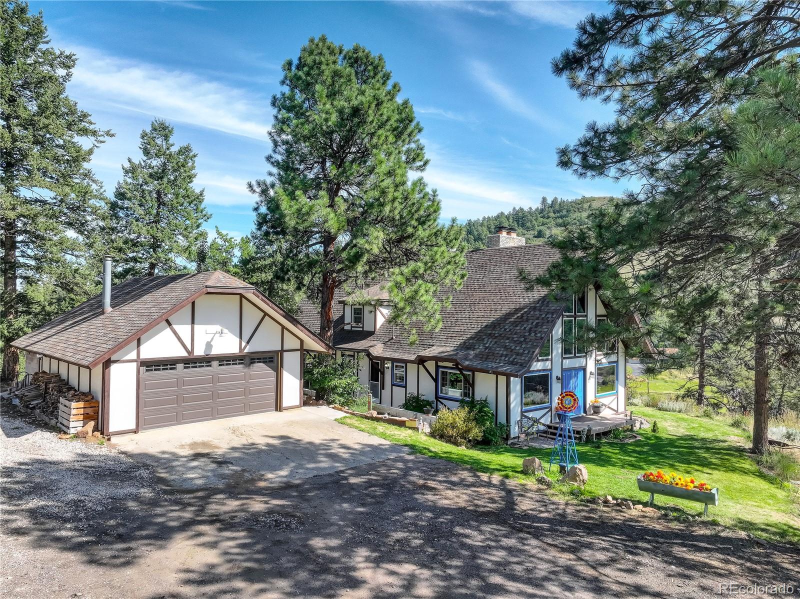 19285 Fox Den Way Morrison, CO 80465 - Photo 2 of 24 a front view of a house with a yard