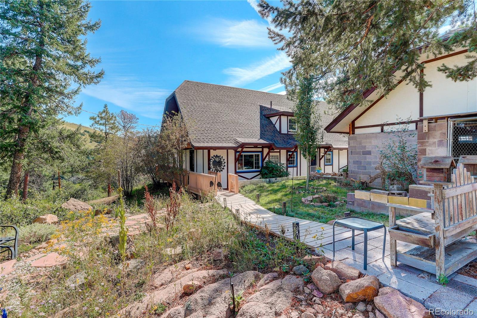 19285 Fox Den Way Morrison, CO 80465 - Photo 21 of 24 a front view of a house with garden and sitting area
