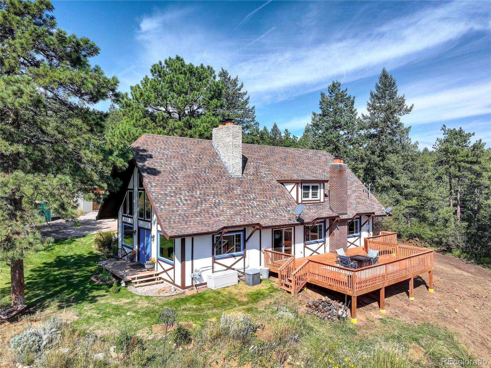 19285 Fox Den Way Morrison, CO 80465 - Photo 3 of 24 a backyard of a house with table and chairs