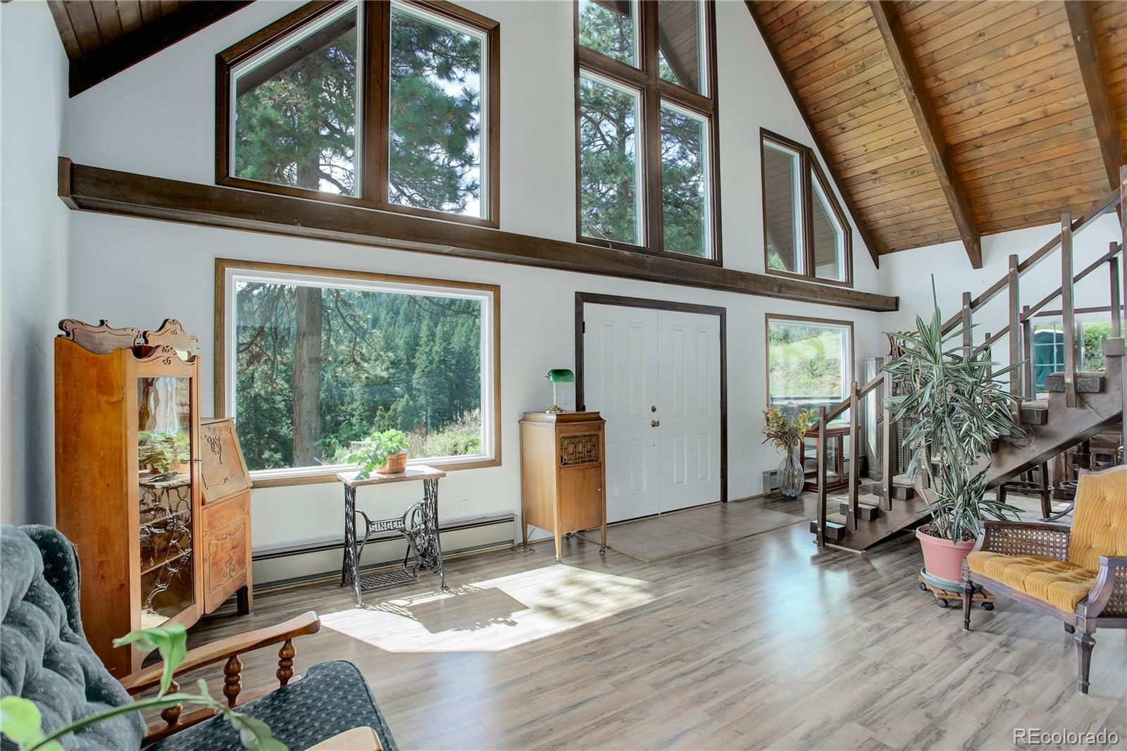 19285 Fox Den Way Morrison, CO 80465 - Photo 6 of 24 a living room with furniture a wooden floor and a large window