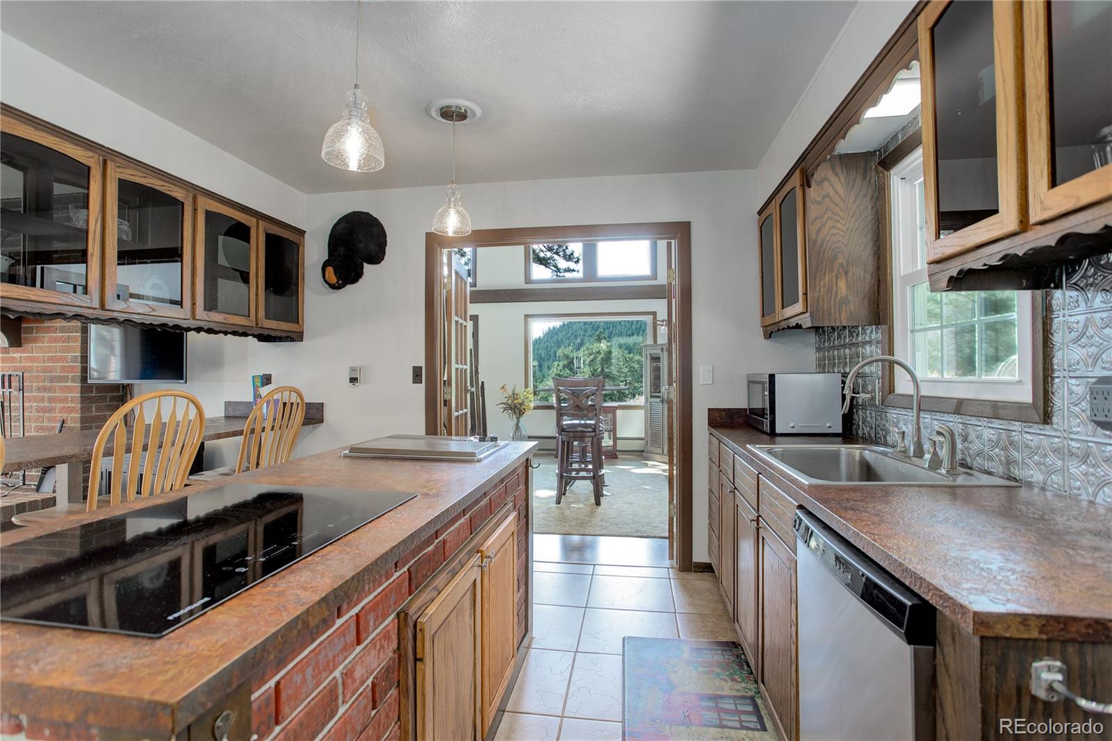 19285 Fox Den Way Morrison, CO 80465 - Photo 8 of 24 a kitchen with kitchen island granite countertop a sink and a stove top oven