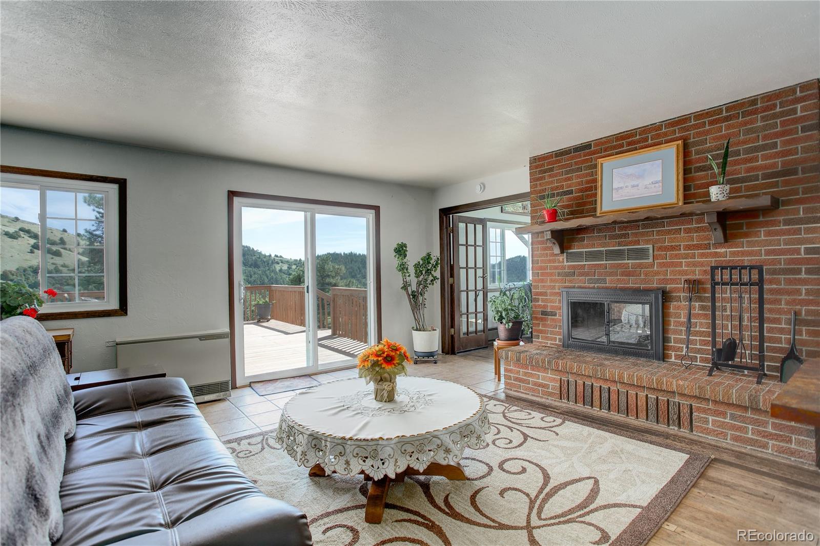 19285 Fox Den Way Morrison, CO 80465 - Photo 10 of 24 a living room with furniture a fireplace and a table