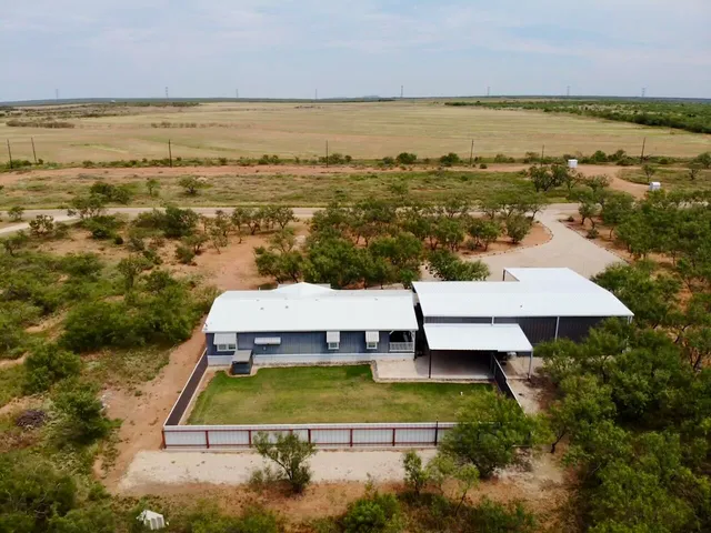 a aerial view of a house with a garden and lake view