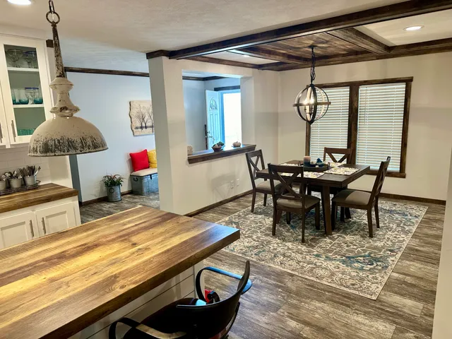 a kitchen with stainless steel appliances granite countertop a stove a sink a microwave a dining table and chairs