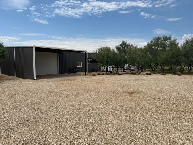 a backyard of a house with fire pit and trees