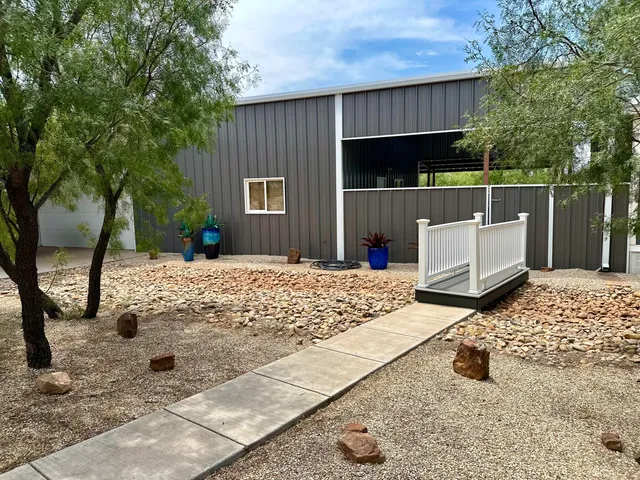 a view of backyard with wooden fence and large trees