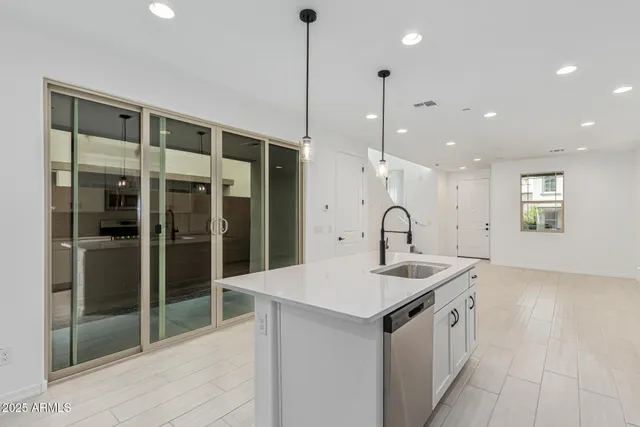 a kitchen with stainless steel appliances kitchen island granite countertop a sink a stove and a refrigerator