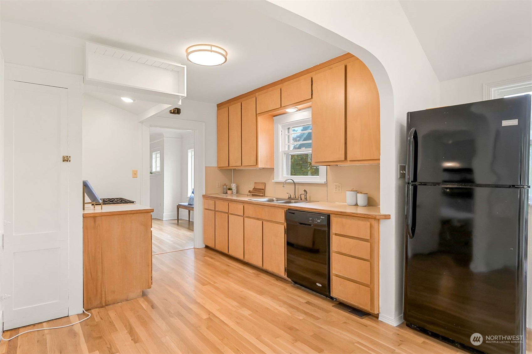 914 Mason Street Bellingham, WA 98225 - Photo 14 of 40 a large kitchen with a refrigerator a sink dishwasher a stove and a dining table with wooden floor