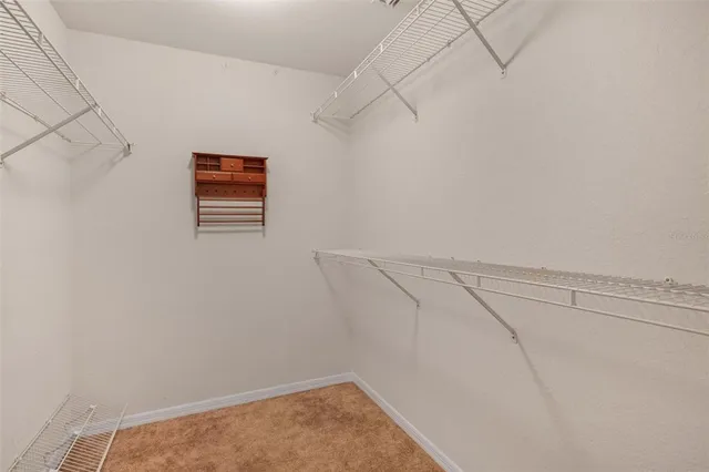 a view of an empty room with a chandelier fan