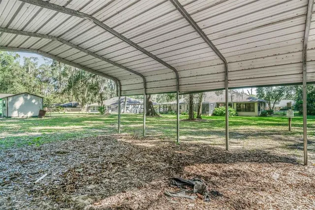 an empty room with a chandelier fan and windows