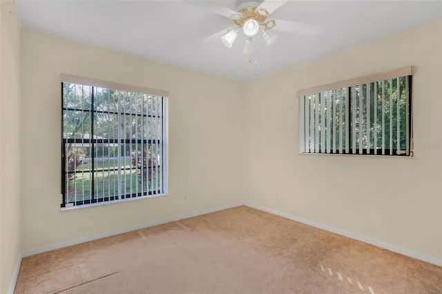 a view of a house with a yard plants and large tree