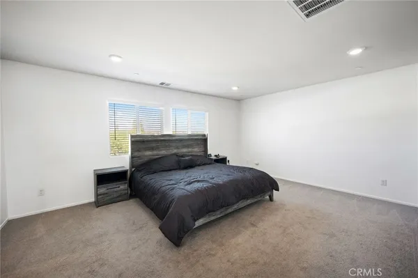 a spacious bedroom with a bed and a window