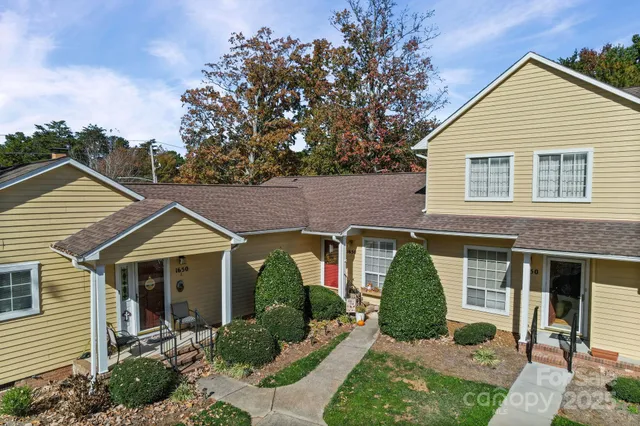 a view of a house with a yard and potted plants