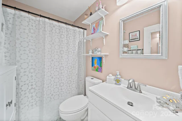 a bathroom with a sink mirror and a toilet