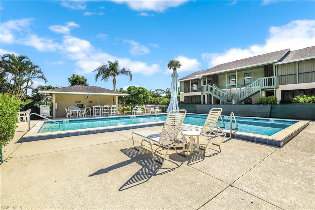 5501 Rattlesnake Hamm Road, Unit 109 Naples, FL 34113 - Photo 3 of 17 a view of a patio with a table and chairs