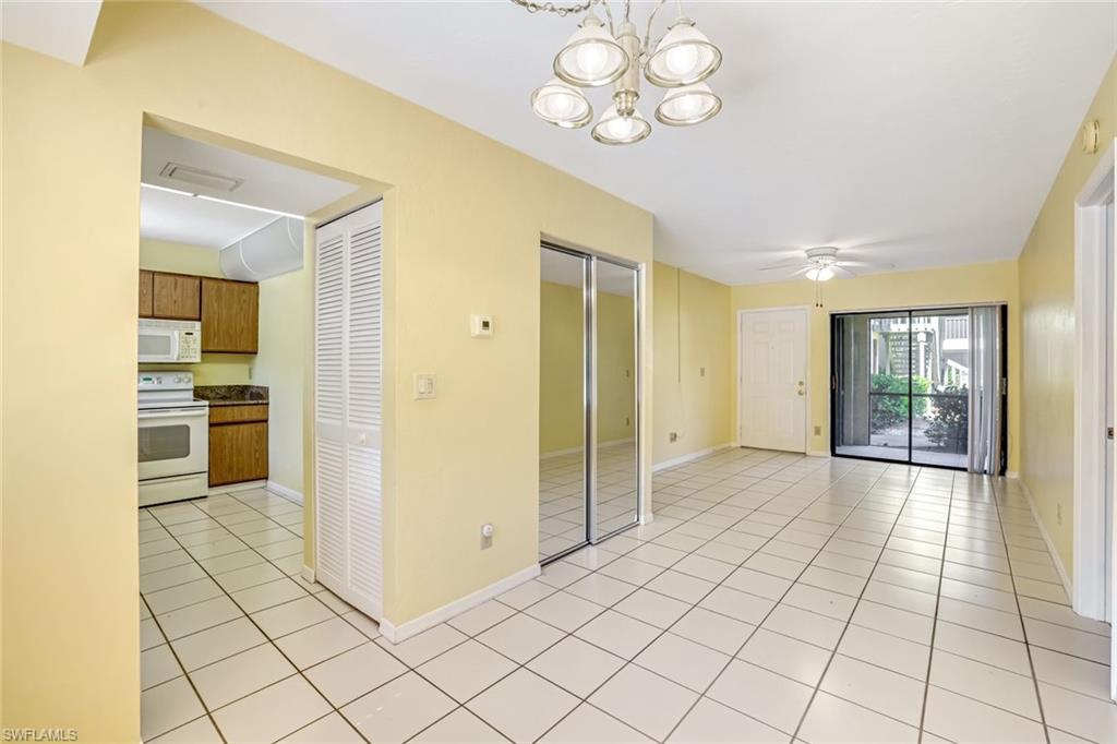 5501 Rattlesnake Hamm Road, Unit 109 Naples, FL 34113 - Photo 6 of 17 a view of a hallway with wooden floor and a kitchen