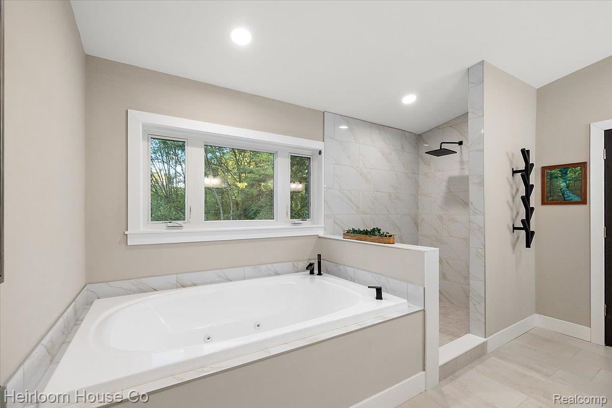 49001 Hanford Road Canton, MI 48187 - Photo 53 of 98 Soaking tub with jets, marble-look tile surround, and black fixtures