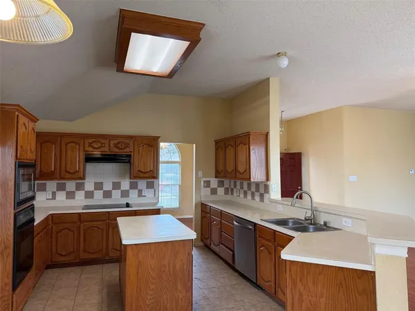 a kitchen with stainless steel appliances granite countertop a sink stove and cabinets