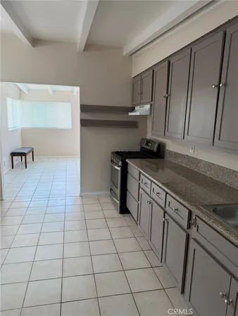 a kitchen with stainless steel appliances a sink stove and cabinets