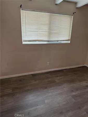 an empty room with wooden floor and door