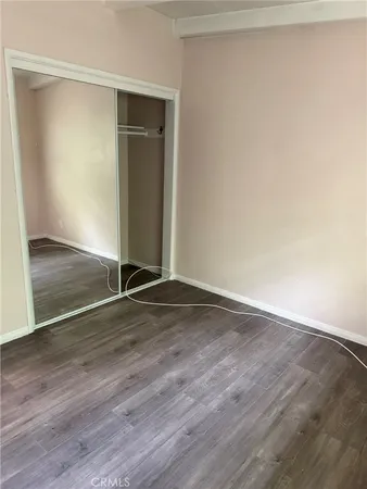 an empty room with wooden floor and closet
