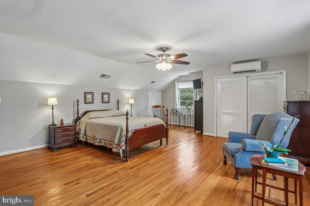 3612 Littledale Road Kensington, MD 20895 - Photo 46 of 79 a spacious bedroom with a bed a couch and a potted plant on the dresser