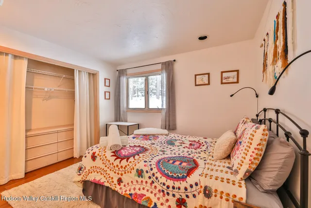 a living room with furniture a flat screen tv and a floor to ceiling window