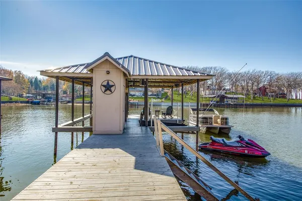 a roof deck with table and chairs a barbeque with wooden floor and lake view