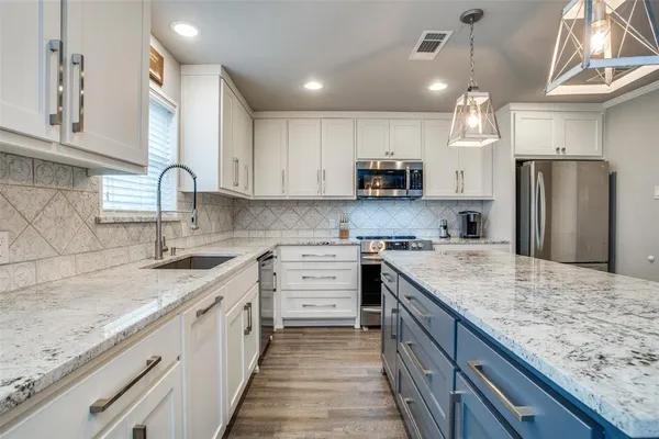 a kitchen with stainless steel appliances granite countertop a sink stove and refrigerator