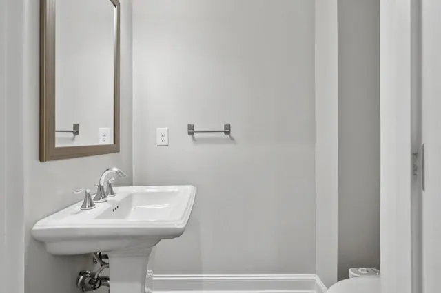 a bathroom with a sink a toilet and mirror